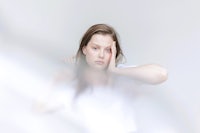 a young woman with her hand on her face