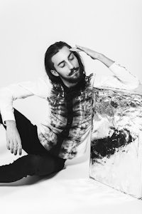 a man sitting on the floor with a silver box