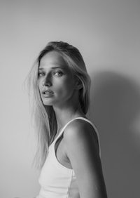 a black and white photo of a woman in a white tank top
