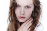 a young woman with blue eyes posing for a photo